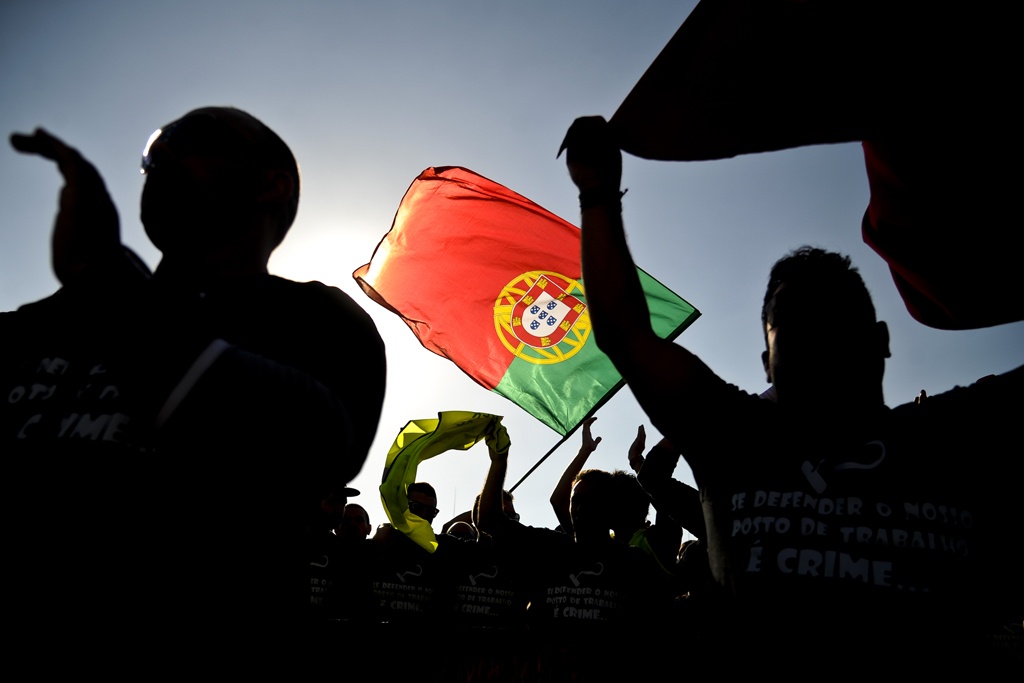 People wave the Portuguese flag during a protest against government's austerity policies at the Terreiro do Paco Square in Lisbon on September 29, 2012. Thousands of Portuguese took to the streets of Lisbon today in a new protest against government financial policies expected to get even tougher to meet pledges to creditors. AFP PHOTO/ PATRICIA DE MELO MOREIRA (Photo credit should read PATRICIA DE MELO MOREIRA/AFP/GettyImages)